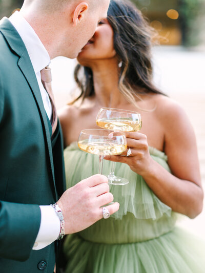 couple kissing holding cocktails