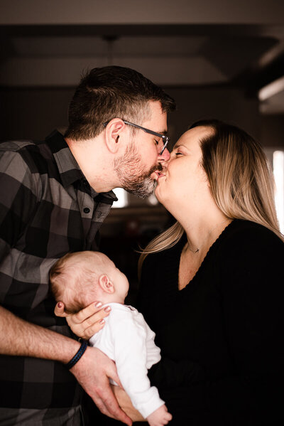 Kissing parents and their newborn in Oshawa photo