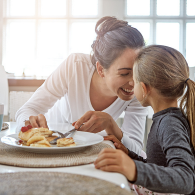 Thrive by Spectrum Pediatrics image for thrive pyramid: overcoming feeding challenges downloadable resource is a child and mother happily eating together during mealtime