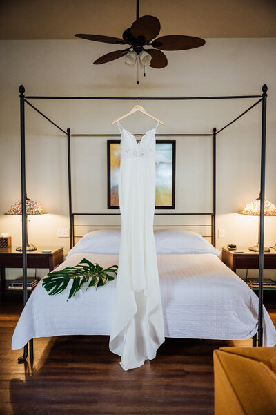 big island wedding dress hanging on bed