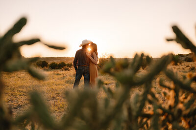 A couple kissing at sunset among cactus