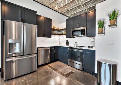 Kitchen with stainless steel appliances in this one-bedroom, one-bathroom luxury condo in the historic Behrens building in downtown Waco, TX.
