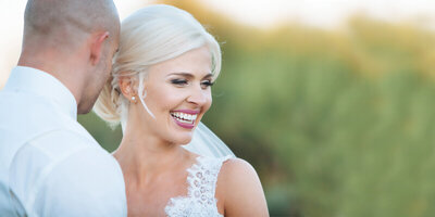 beautiful bride smiling with groom