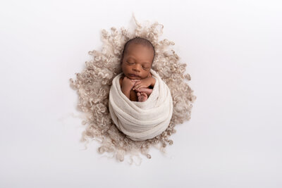Newborn baby in cream wrap