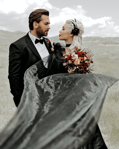 man-in-black-suit-holding-bouquet-of-flowers-3650469