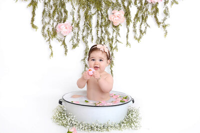 girl smiles while in her floral milk bath