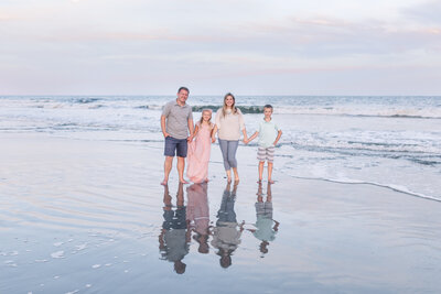 Karen Schanley, wedding and portrait photographer, and family pose on beach  in South Carolina.