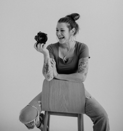 woman sitting on chair with camera