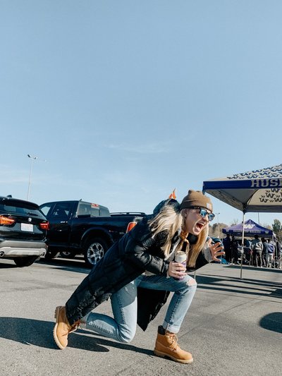 Emma Studley kneeling at a tailgate