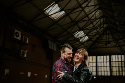 A couple hugging and laughing during their engagement shoot in West Yorkshire
