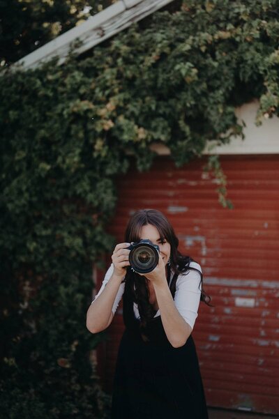 Branding photo of Sharni Tolhurst holding her camera during a photoshoot.