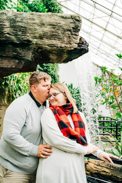 For their engagement photography session, a couple poses in botanical gardens in Fort Wayne, Indiana.