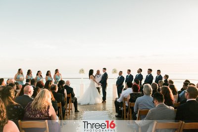 Bride and Groom hold hands as they face each other while taking their vows at the Surf and Sand Resort
