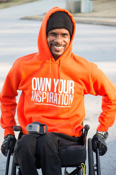 Inspirational speaker in wheelchair wearing orange hoodie