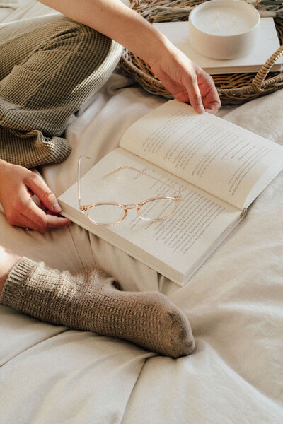 cozy setting woman reading book on bed