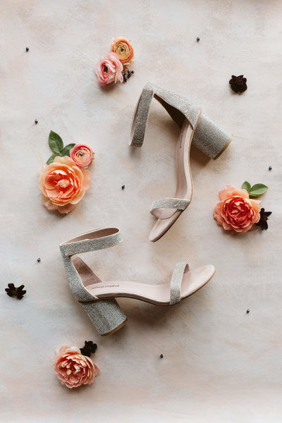 shoes and coral flowers on ground