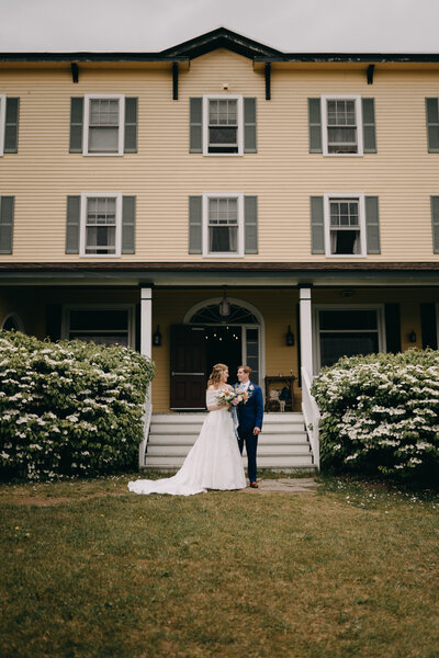 New England couple in front of home after wedding