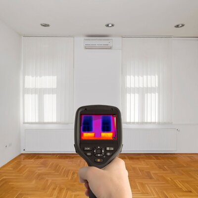 Thermal Imaging gun pointed at wall showing temperature differences with infared technology