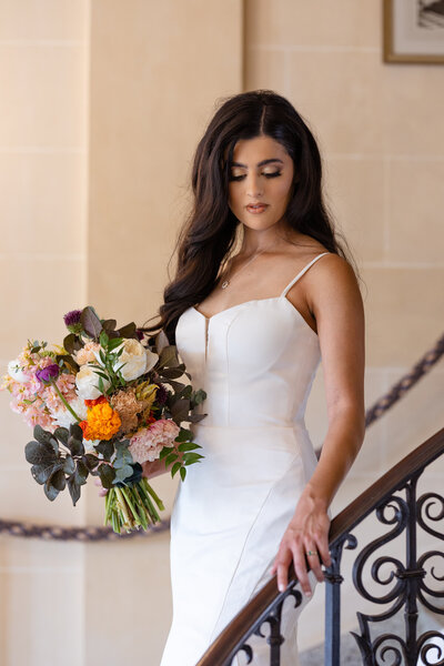 bride standing on a staircase holding a flower bouquet