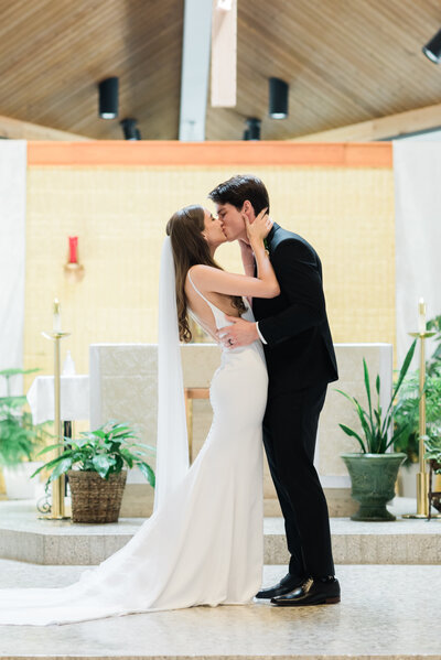 Bride and groom share first kiss at OUr Lady of the Lake Catholic Church in Minnetonka