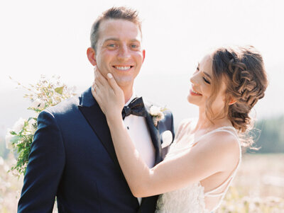 AZ Wedding Photographer Ball Photo Co Groom smiling at the camera with the bride holding his face and smiling at him
