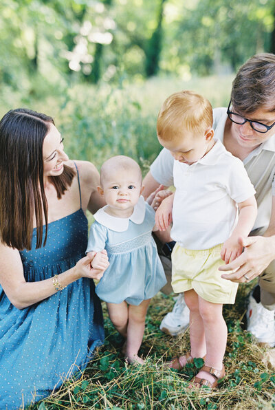 A family plays in a grassy field during their family session with Chattanooga photographer Kelsey Dawn Photography