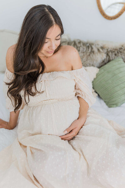 sweet photography moment of a mother looking down at her pregnancy bump. Captured by Folsom photographer  at Bendel Photography in Folsom, CA.