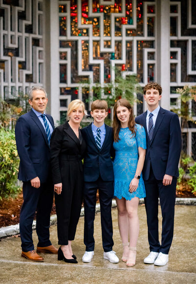 A family of five stand together in a temple garden during a Bellevue Bar and Bat Mitzvah Photography session