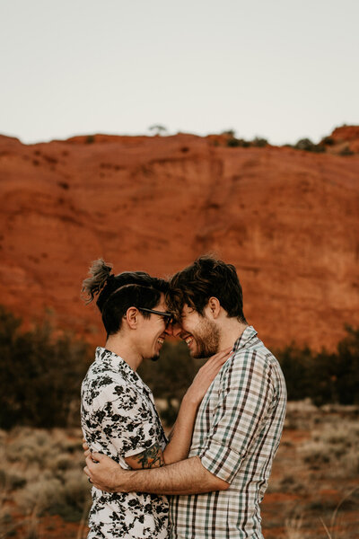 same sex couple looking into each others eyes at the red rocks in New Mexico