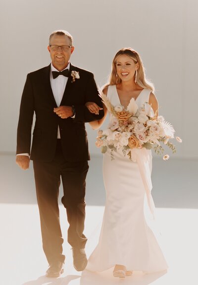 Bride Walking Down the Aisle with Father - Bre & Chris | Converted Basketball Court Wedding – Featured in Brides Magazine