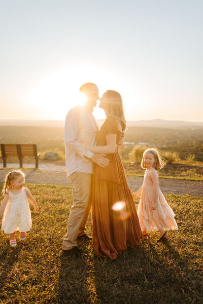 family standing in golden hour on a field