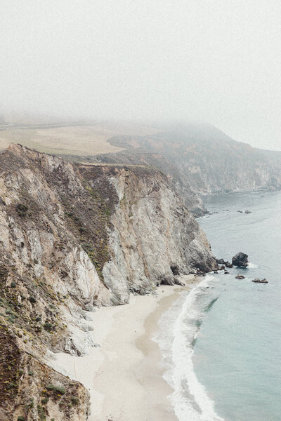 grand landscape of big sur and the waves crashing on shore on a foggy day