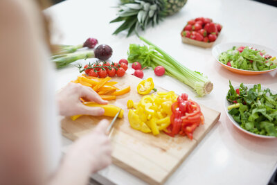 Variety of vegetables being chopped on a chopping board