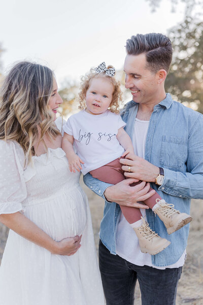 beautiful family having their pregnancy announcement photos done in Folsom, CA by photographer Caroline Bendel