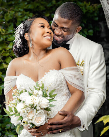 A joyful bride and groom embracing outdoors after their wedding ceremony, showcasing emotional storytelling by a UK wedding photographer and videographer.

