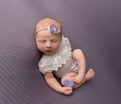 Newborn portrait of a baby girl in a bamboo prop chair