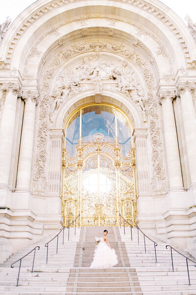 Wedding Photography a bride stands on the stairway before palace gates