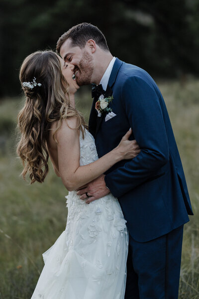 groom and bride kiss during sunset wedding portraits in Estes Park.