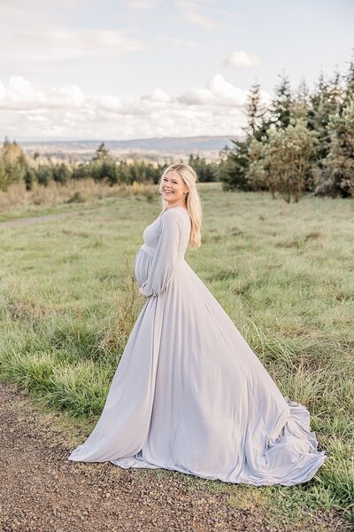 pregnant mom in grey long gown with field view of Willamette Valley