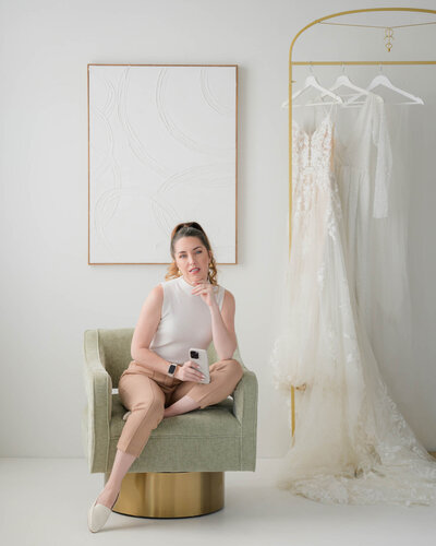 kaylyn leighton's back to the camera as she steams wedding gown for a client.