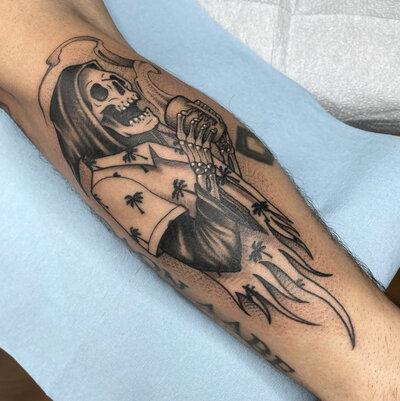 A black and gray tattoo of a brain and a jellyfish.