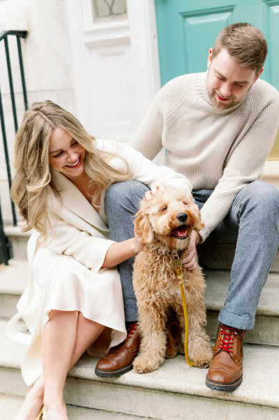 couple sits on steps with dog