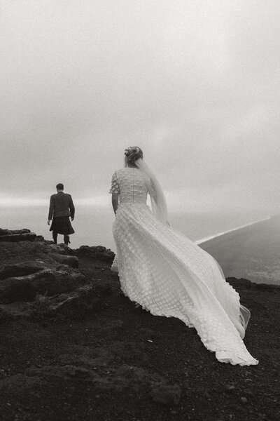 bride and groom in Iceland overlooking black sand beach