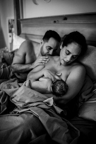 Mother and father in bed after homebirth of baby