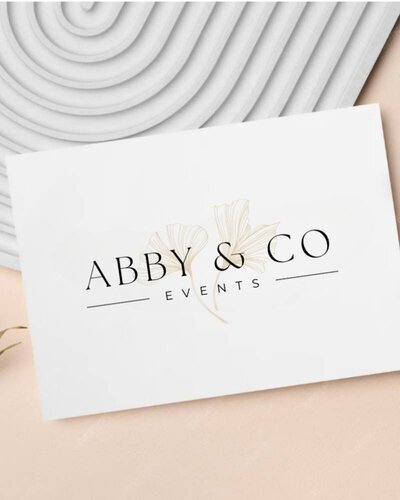 White card with Abby & Co Events logo in black typography and floral illustration