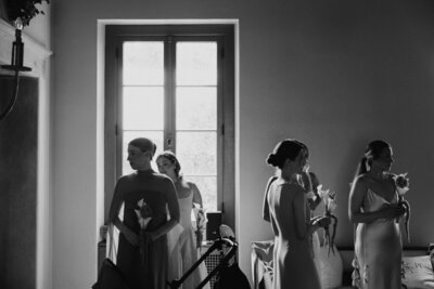black and white image of bridesmaids off guard waiting for ceremony in front of window in jekyll island, georgia 