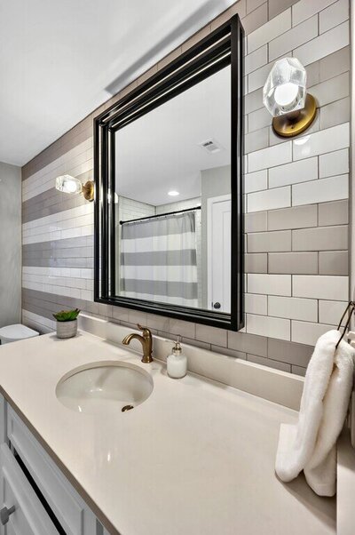 Guest bathroom with two toned subway tile of this three-bedroom, two-bathroom vacation rental home featured on Chip and Joanna Gaines' Fixer Upper located in downtown Waco, TX.