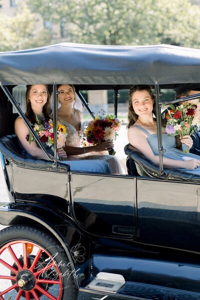 Bride in small cart with bridesmaids