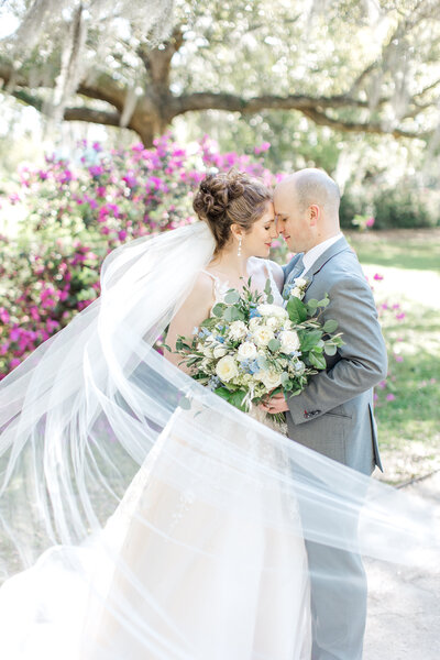 Newlywed bride and groom hold each other at the Magnolia Plantation in South Carolina.