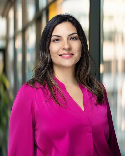 Professional headshot of Rocio with a confident smile and soft natural lighting, photographed on a neutral background by Liza Hondros Photography in Fayetteville, NC.